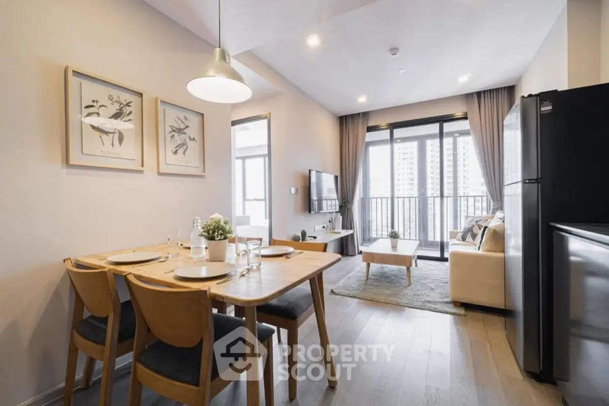 Modern open-plan living and dining area with balcony view in stylish apartment.