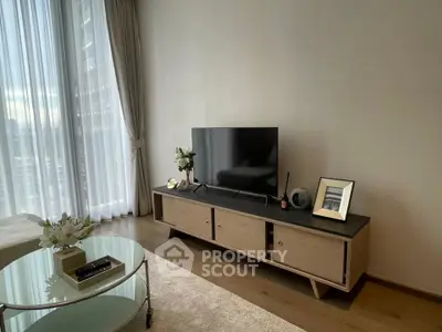 Modern living room with sleek TV stand and large window, offering a bright and inviting atmosphere.