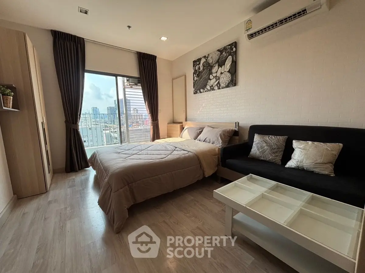 Modern bedroom with city view, featuring cozy bed, stylish sofa, and large window for natural light.