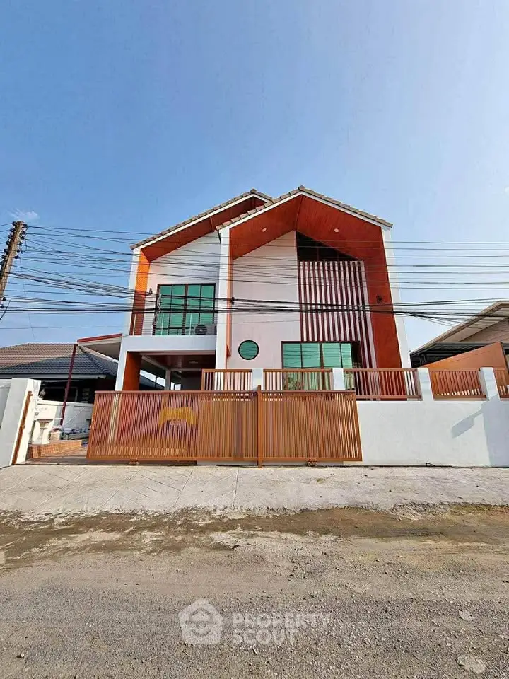 Modern two-story house with unique architectural design and spacious front yard.