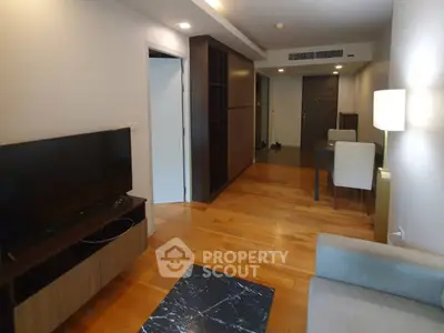 Modern living room with wooden flooring and sleek furniture in a cozy apartment.