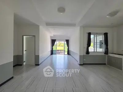 Spacious modern living room with large windows and elegant tile flooring