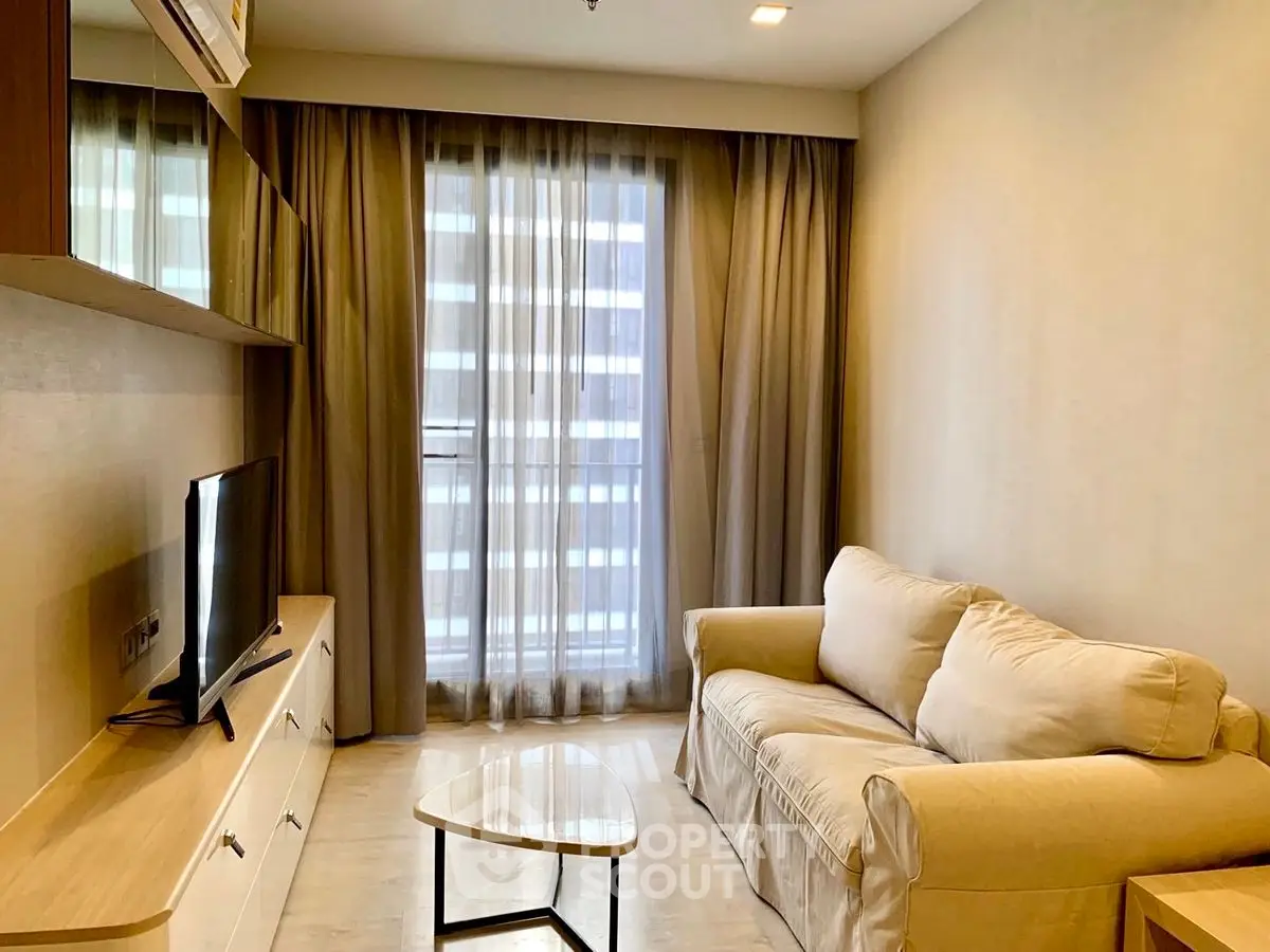 Cozy living room with beige sofa and modern TV setup in a stylish apartment.