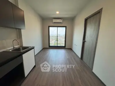 Modern minimalist kitchen with sleek cabinetry and large window offering city views.