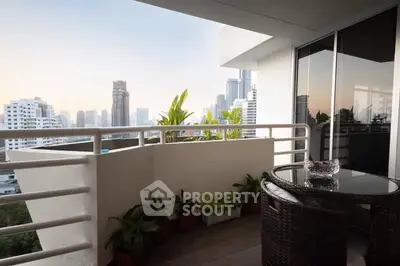 Modern balcony with city skyline view and stylish outdoor furniture.
