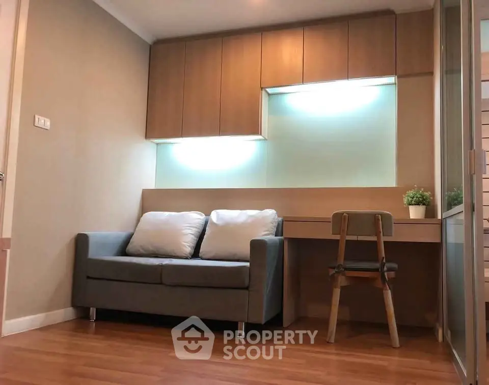 Cozy living room with modern sofa and built-in desk, perfect for small apartments.