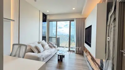 Modern living room with large windows and city view, featuring sleek furniture and stylish decor.