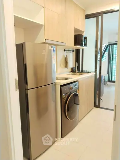 Modern kitchen with sleek appliances and open layout in stylish apartment.