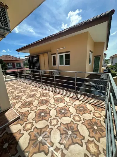 Spacious balcony with decorative tiles and modern exterior view under clear blue sky.