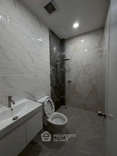 Modern bathroom with sleek tiles and contemporary fixtures in a stylish real estate property.