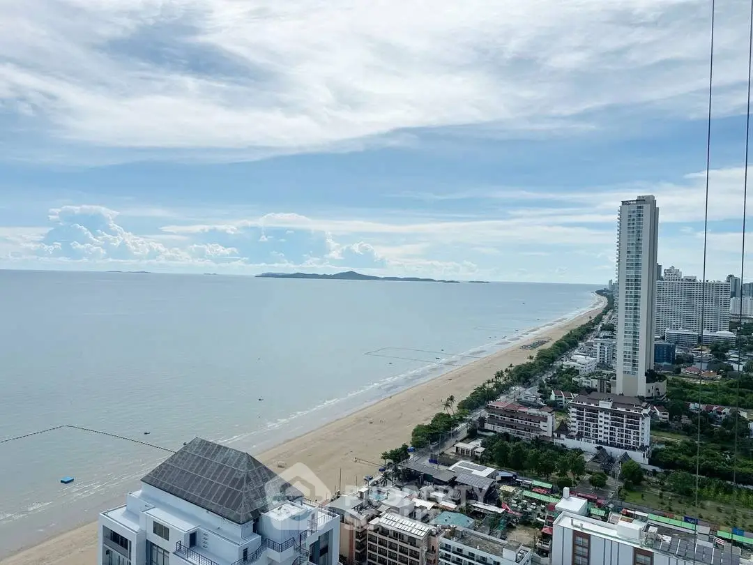 Stunning beachfront view from high-rise building overlooking ocean and cityscape.