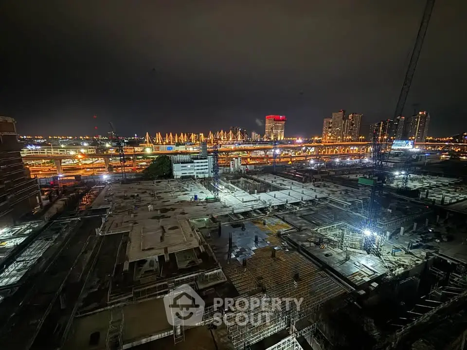 Nighttime construction site with city skyline and cranes, showcasing urban development potential.