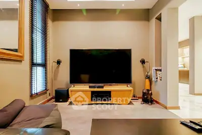 Modern living room with large TV and stylish decor, perfect for entertainment.
