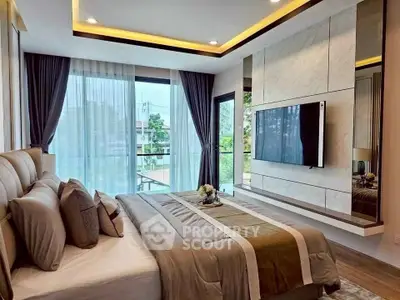 Luxurious modern bedroom with large windows and elegant decor, featuring a wall-mounted TV and scenic view.