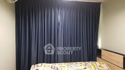 Cozy bedroom with dark curtains and colorful bedding, perfect for restful nights.