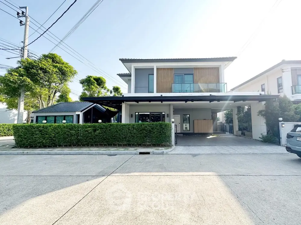 Modern two-story house with spacious driveway and lush greenery