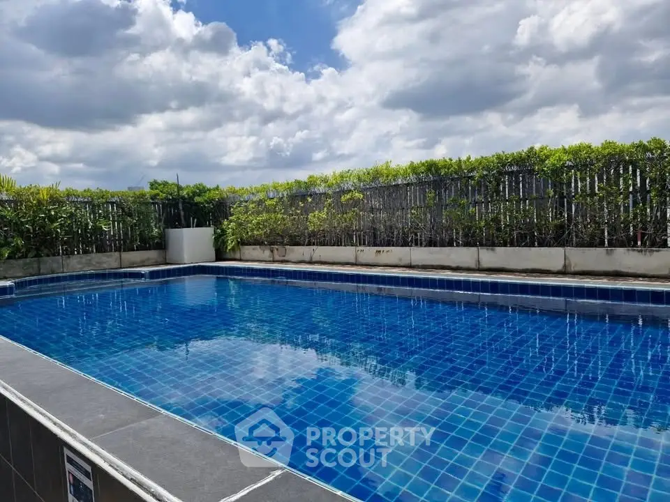 Luxurious rooftop pool with stunning sky view and lush greenery, perfect for relaxation and leisure.