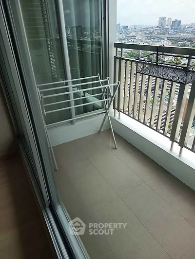 Modern apartment balcony with city view and drying rack, perfect for urban living.