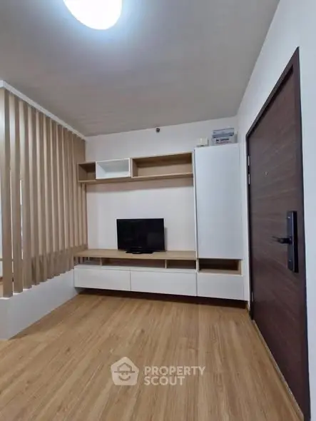 Modern living room with wooden flooring and built-in TV unit, perfect for cozy family gatherings.