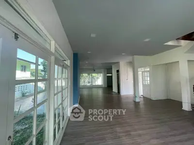 Spacious open-plan living area with large windows and modern flooring, perfect for natural light and contemporary living.