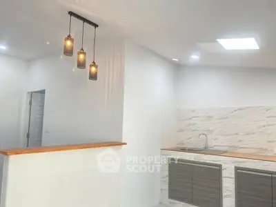 Modern kitchen with stylish pendant lights and sleek cabinetry in a bright, open space.