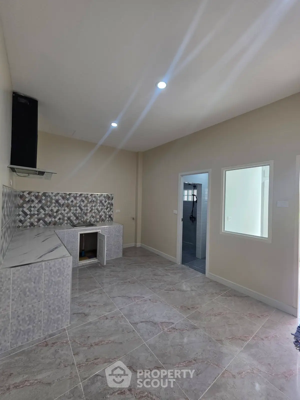 Modern kitchen with tiled backsplash and open layout, featuring sleek countertops and ample natural light.
