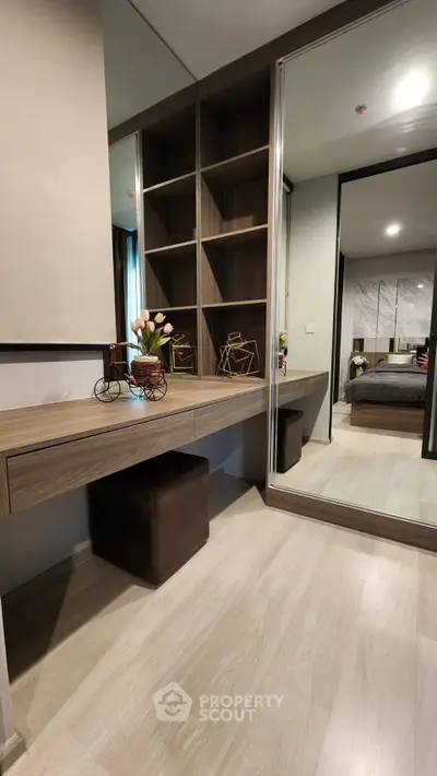 Modern bedroom with stylish wooden shelves and mirrored wardrobe