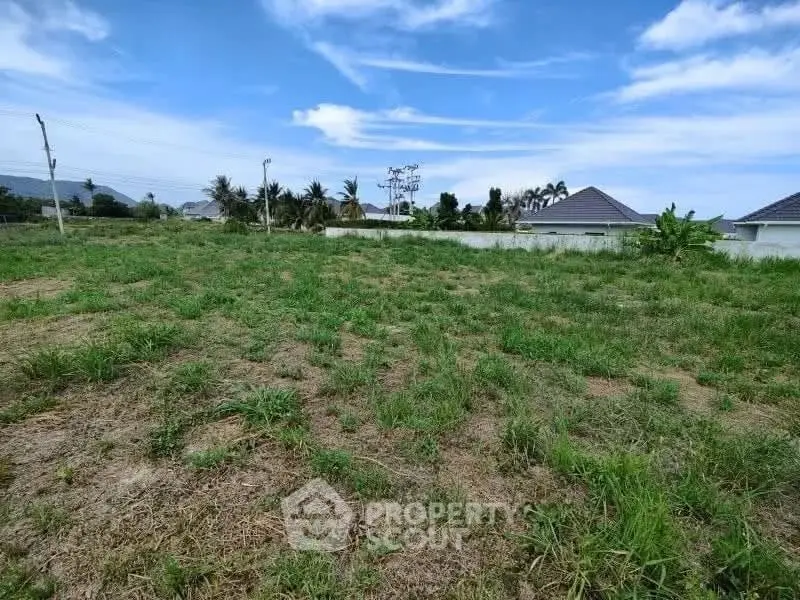 Spacious vacant land with lush greenery and clear blue sky, ideal for building your dream home.