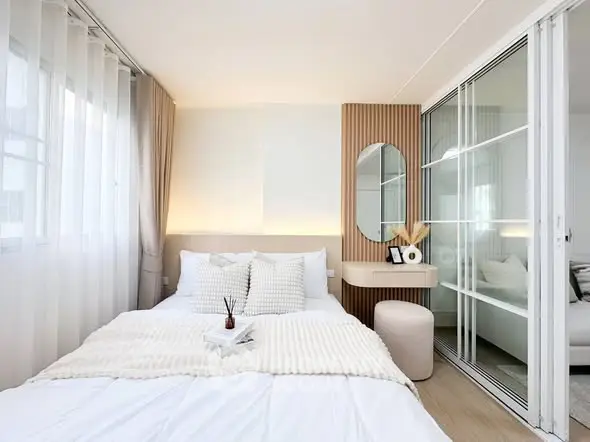 Modern bedroom with elegant decor and natural light in a stylish apartment.