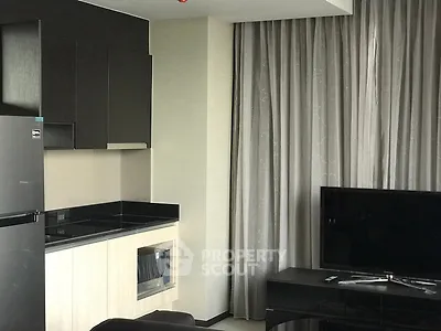 Modern living room with sleek kitchen corner and TV setup