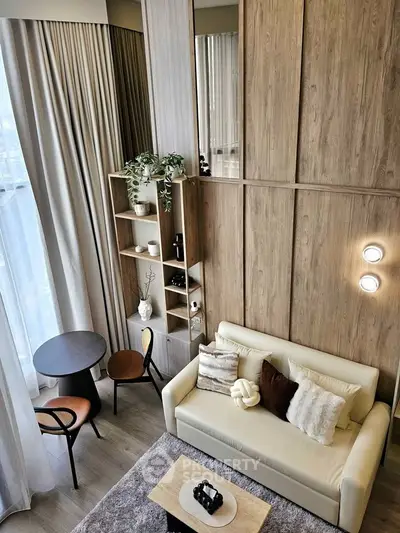Stylish modern living room with high ceilings, elegant decor, and cozy seating area.