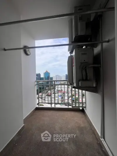 High-rise balcony with cityscape view and air conditioning units.