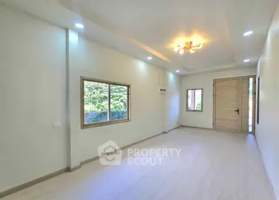 Spacious and bright living room with modern lighting and large windows.