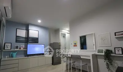 Modern living room with stylish decor and sleek furniture, featuring a TV and wall art.