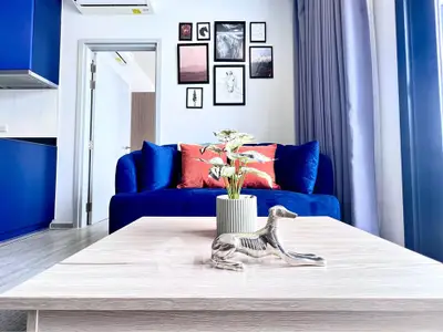 Stylish modern living room with blue sofa, art wall, and elegant decor in a bright apartment.