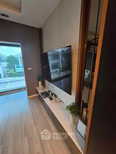 Modern living room with sleek TV setup and large window view.