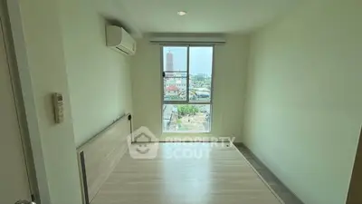 Spacious bedroom with large window offering city view, featuring air conditioning and modern flooring.