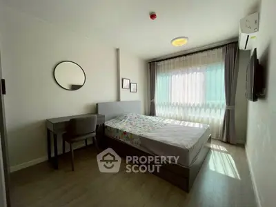 Modern bedroom with natural light, featuring a bed, desk, and stylish decor.