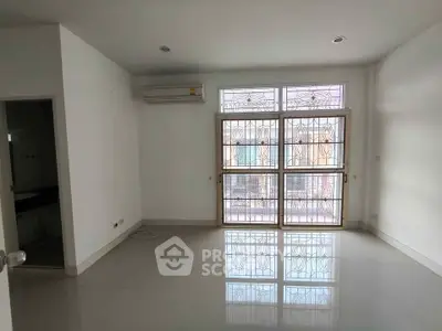 Spacious unfurnished living room with large windows and air conditioning unit.