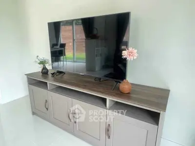 Modern living room with sleek TV stand and large flat-screen TV