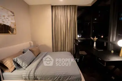 Cozy bedroom with modern decor and large window offering night view