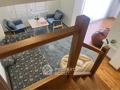 Charming loft-style living room with cozy seating and wooden accents, perfect for relaxation and entertaining.