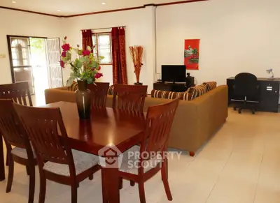 Spacious living room with elegant dining area and cozy seating, perfect for family gatherings.