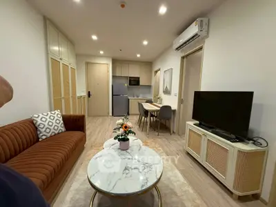 Modern living room with stylish furniture and open kitchen layout in a cozy apartment.