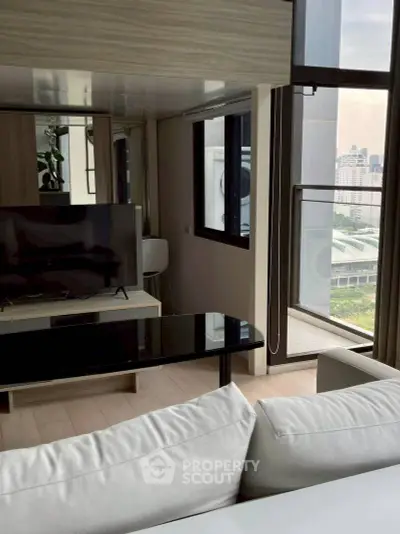 Modern living room with sleek furniture and city view balcony