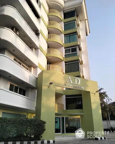 Modern condominium building exterior with unique architectural design and lush greenery.