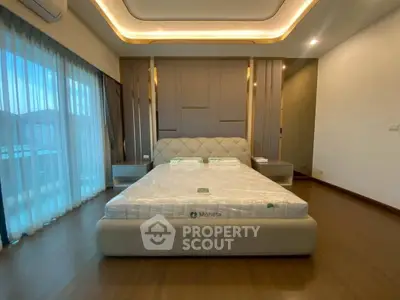 Luxurious bedroom with modern design and large windows offering natural light.
