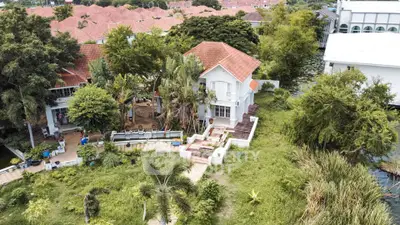 Charming house with red roof surrounded by lush greenery and trees