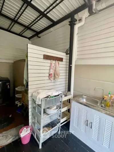 Charming utility area with sink and storage, perfect for laundry or kitchen extension.