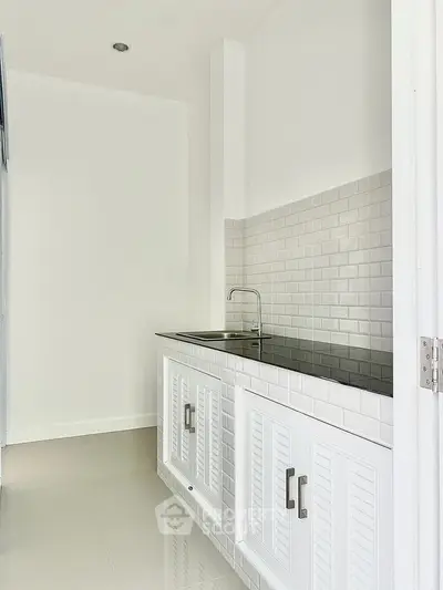 Modern minimalist kitchen with sleek white cabinetry and subway tile backsplash